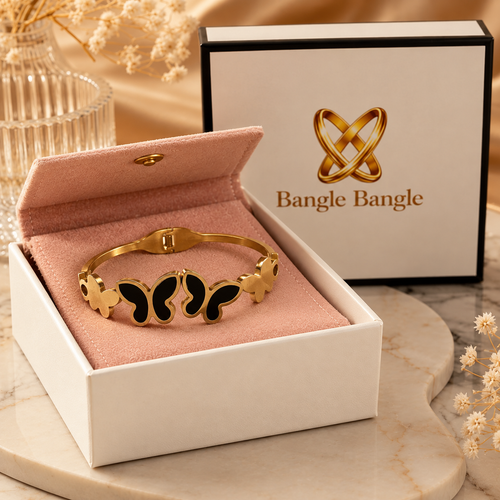 18K gold plated black butterfly cuff bangle in open Bangle Bangle white gift box with black trim and pink pouch on marble surface — Bangle Bangle