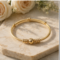 18K gold plated twisted cable bangle on marble surface \| Bangle Bangle