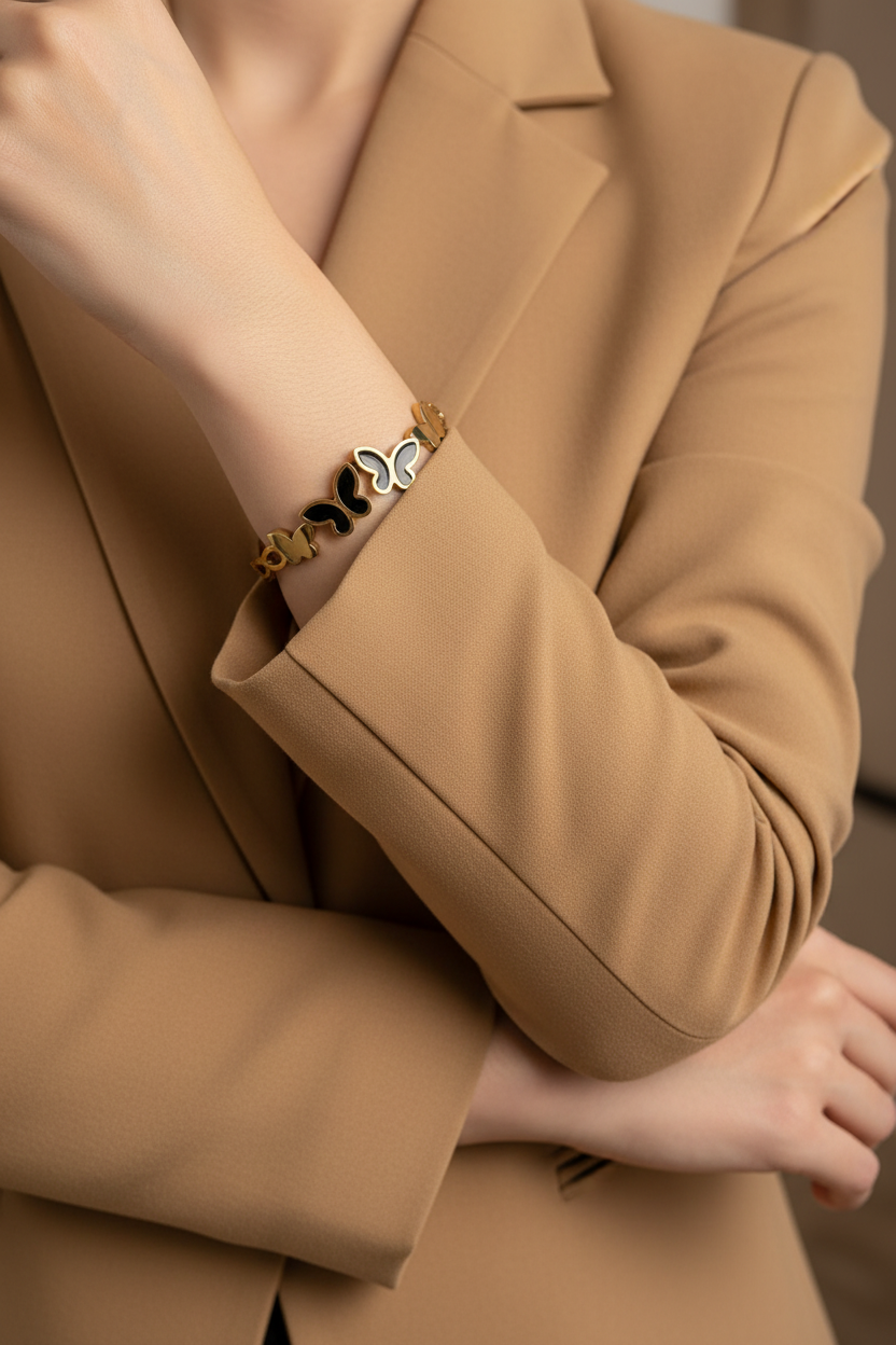 18K gold plated black butterfly cuff bangle worn on a woman's wrist with camel blazer sleeves pushed up — Bangle Bangle