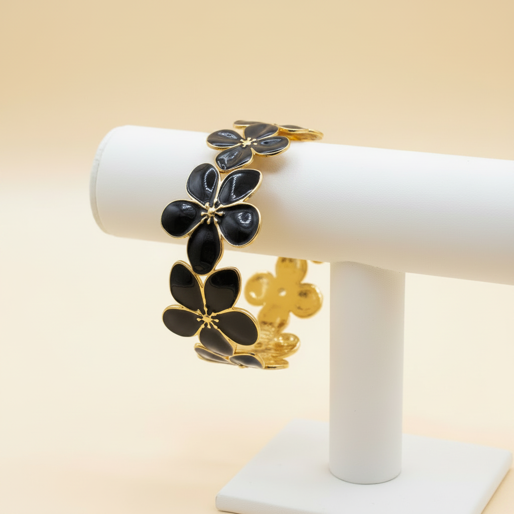 18K gold plated black floral blossom cuff bangle with black enamel petals displayed on a jewellery stand — Bangle Bangle