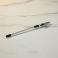Silver bracelet helper tool with alligator clip and rubber tip on a white marble surface — Bangle Bangle