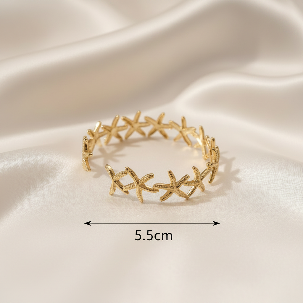 18K gold-plated starfish open cuff bangle side profile on white silk fabric showing full circular cuff with linked starfish design with 5.5cm measurement