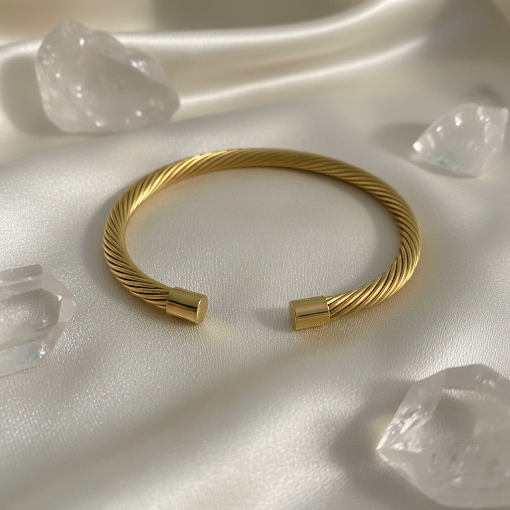 Close-up of 18K gold plated twisted cable open cuff bangle showing intricate multi-strand wire texture and polished square gold end caps on cream satin — Bangle Bangle