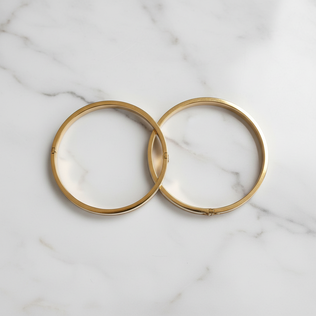 18K gold-plated white enamel inlay bangle set of 2 laid side-by-side on white marble showing crystal bar detail, top-down luxury jewelry photography
