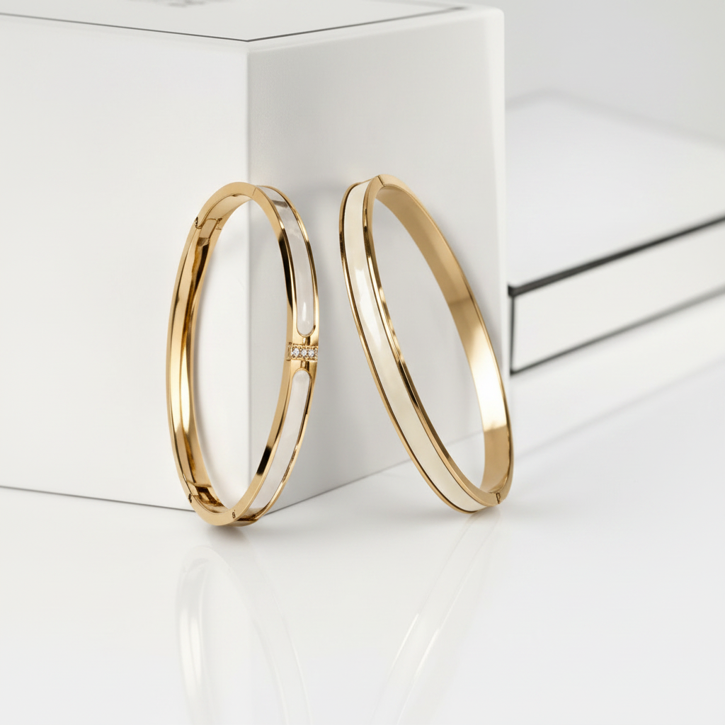 18K gold-plated white enamel inlay bangle set of 2 standing upright against a clean white surface, angled editorial luxury jewelry photography